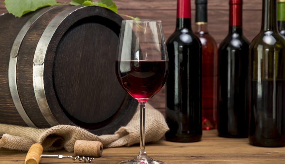 barril-de-madeira-com-garrafas-e-copos-de-vinho